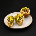 Mignardise en forme de corbeille, pistaches et pignons, coupée pour montrer la farce
